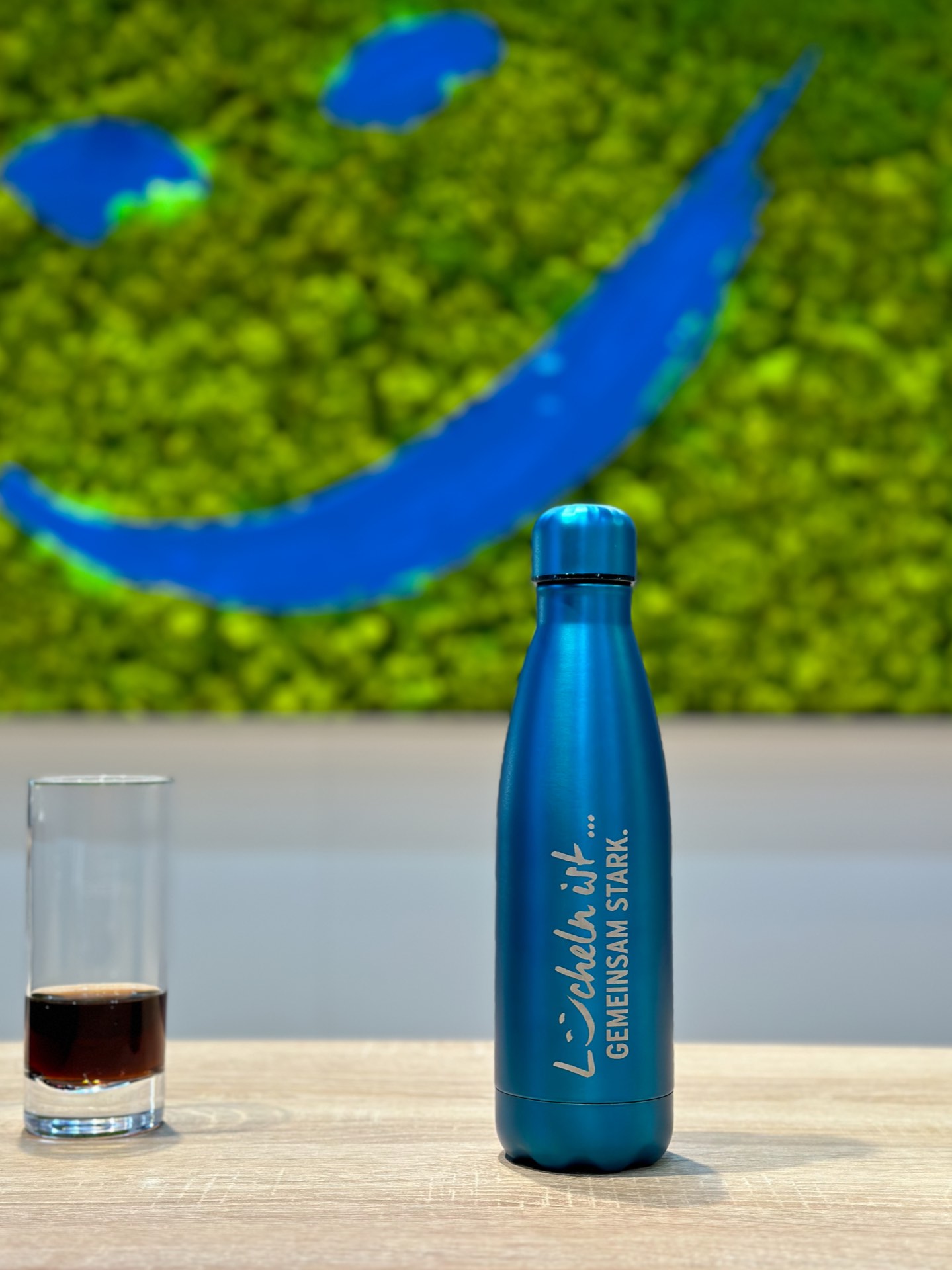 Nachhaltige Glasflasche mit Kächele-Motto: Lächeln ist gemeinsam stark